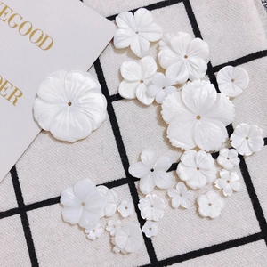 Vue détaillée de fleurs en nacre sculptées avec trou central pour bijoux DIY