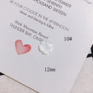 Macro detail of 12mm white shell flower bead with iridescent mother of pearl texture
