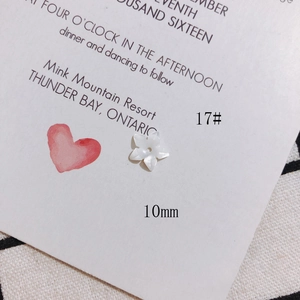 Macro view of a 10mm white shell flower bead with iridescent luster for DIY jewelry