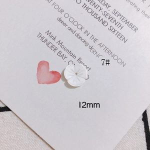 Détail macro d'un accessoire fleur en nacre blanche de 12mm à cinq pétales pour bijoux DIY