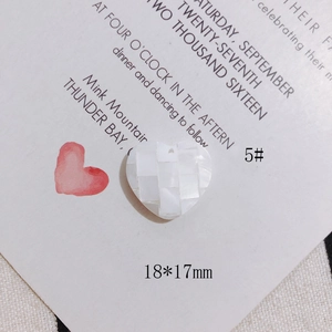 Macro detail of a 18x17mm heart-shaped pendant made of mosaic white mother of pearl tiles