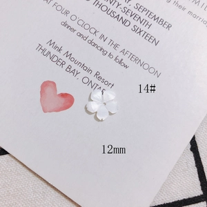 Gros plan d'une fleur de nacre blanche de 12 mm sculptée pour création de bijoux DIY