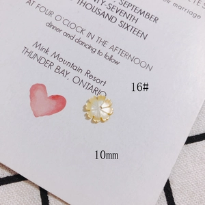 Dettaglio macro di perla a fiore in madreperla bianca scolpita da 10 mm per gioielli fai-da-te