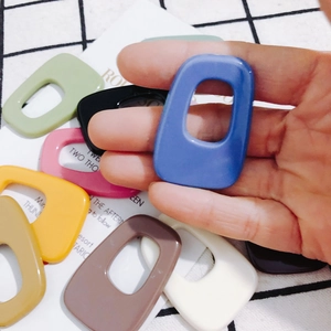 Detailed view of colorful hollow rectangular acrylic charms for DIY jewelry making