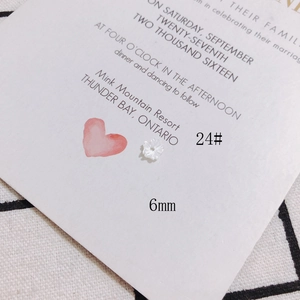 Vue macro d'une perle fleur en nacre de 6mm pour bijoux DIY sur une carte imprimée