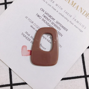 Macro detail of a brown hollow trapezoid acrylic pendant for DIY jewelry making