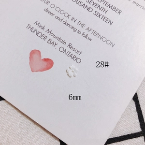 Gros plan de perles fleurs en coquillage blanc 6mm pour bijoux DIY sur fond esthétique