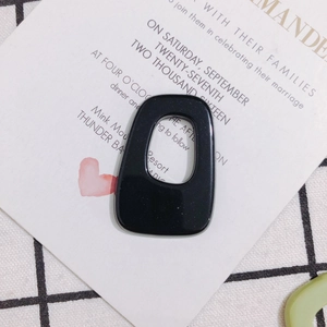 Macro view of a glossy black irregular hollow acrylic trapezoid for DIY jewelry making