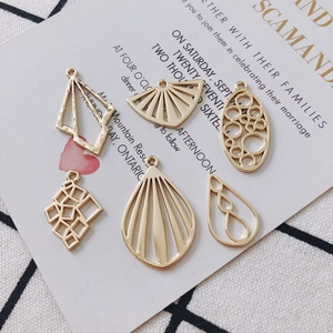 Gold alloy geometric pendant set with fan and oval shapes featuring a hammered texture