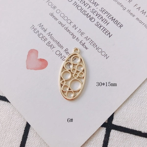 Detail of 30x15mm golden geometric oval charm with circular cutouts for DIY jewelry