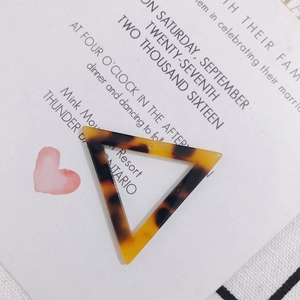 Gros plan d'un pendentif triangle en acétate écaille pour la création de bijoux DIY