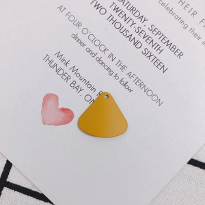 Macro detail of a bright yellow fan-shaped alloy pendant for DIY jewelry making and crafts