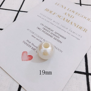 Detailed view of 19mm iridescent faux pearl bead with champagne gold wrinkled texture