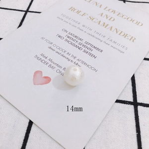 Detail shot of a 14mm white pearlescent bead with a glossy finish for DIY jewelry