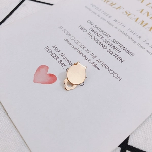 Détail de clips d'oreilles dorés pour la création de bijoux sur une carte décorée