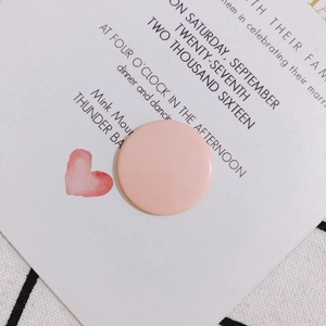 Vista macro de un sello decorativo de acrílico rosa en una tarjeta de invitación