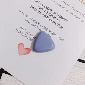 Macro view of light purple resin triangle charm for DIY jewelry on a white card