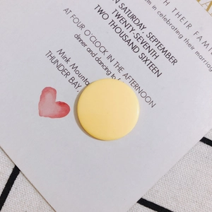 Primer plano de un dije redondo de acrílico amarillo mate para pendientes y joyería artesanal
