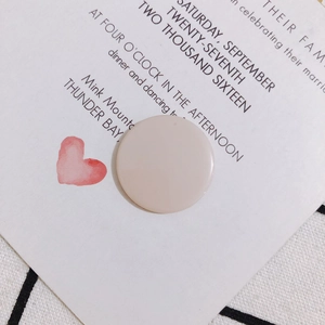 Detalle de cabujones redondos de acrílico rosa claro sobre una invitación romántica
