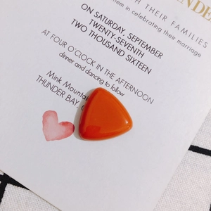 Detailed close-up of a polished orange triangular resin cabochon for jewelry making