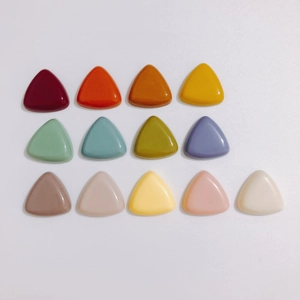 Flat lay of colorful triangular resin charms with glossy finish for DIY jewelry crafts