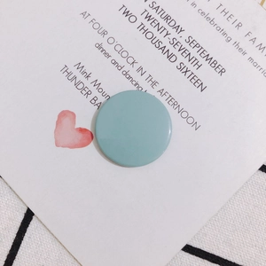Primer plano de un disco acrílico azul claro sobre una tarjeta de invitación de boda