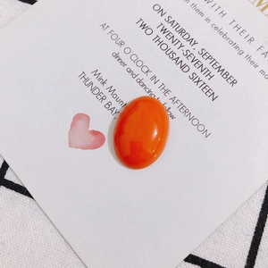 Vue macro d'un cabochon ovale orange brillant sur une carte de présentation