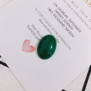 Gros plan d'un cabochon ovale en pierre vert foncé pour création de bijoux DIY