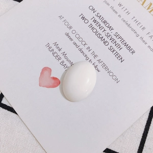 Gros plan d'un accessoire de bijoux ovale blanc poli sur une carte décorative