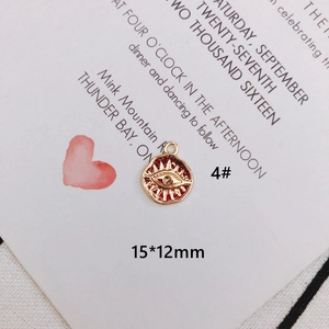 Detail of a 15x12mm evil eye pendant with red enamel and wavy golden edge