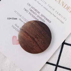 Macro detail of 44mm round dark brown natural wood pendant with pre-drilled hole for DIY