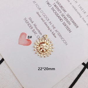 Detail of a 22x20mm gold sun face pendant for DIY jewelry making with relief texture