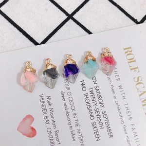 Detailed view of colorful raw stone pendants with gold metal loops for DIY jewelry making