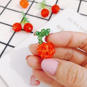 Dettaglio del ciondolo a ciliegia in cristallo rosso fatto a mano con foglie per gioielli DIY