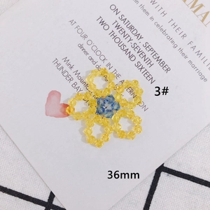 Dettaglio macro del ciondolo a fiore in cristallo intrecciato blu e giallo 36mm per fai da te