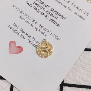 Detail view of 18K gold plated Cancer zodiac pendant with vintage embossed texture