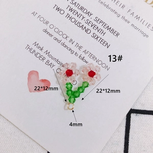 Dettaglio ciondolo a fiore in perline di cristallo rosa con foglia verde e anello d'oro
