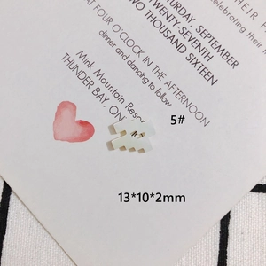 Dettaglio macro del ciondolo zodiacale in madreperla bianca con numero 5 inciso