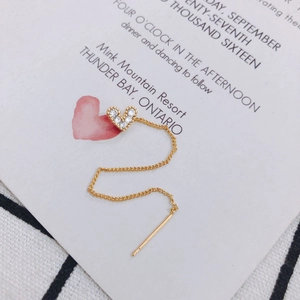 Nahaufnahme der langen goldenen Herz-Ohrring-Kette mit Zirkonia-Pavé und feiner Gliederkette