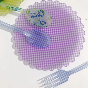 Dettaglio di cucchiai da dessert a fiori e un piatto a quadretti viola stile francese