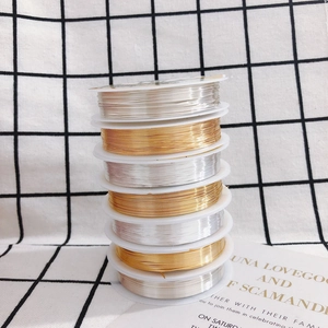 DIY jewelry copper wire in gold and silver finishes on white spools for handcrafting
