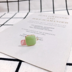 Close-up of a square light green enamel pendant with golden frame for DIY jewelry