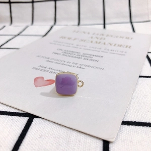 Detailed view of square purple enamel charm with gold metal frame for jewelry making
