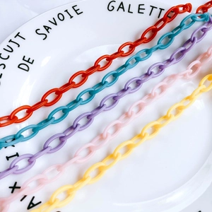 Détail de maillons ovales en acrylique colorés pour la création de colliers et de bracelets