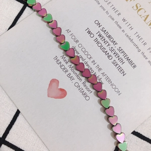 Macro detail of iridescent heart-shaped hematite beads with metallic chameleon gradient finish