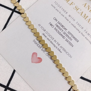 Detail of golden heart-shaped link chain on a romantic wedding card background