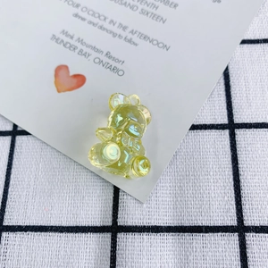 Detail of a transparent yellow acrylic bear pendant with an iridescent shimmering finish