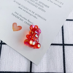 Macro detail of red transparent faceted acrylic bear pendant with iridescent aurora finish