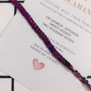 Macro detail of V-shaped hematite beads with iridescent metallic purple gradient finish