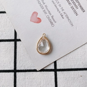 Macro shot of faceted teardrop crystal pendant with gold metal rim for DIY jewelry making